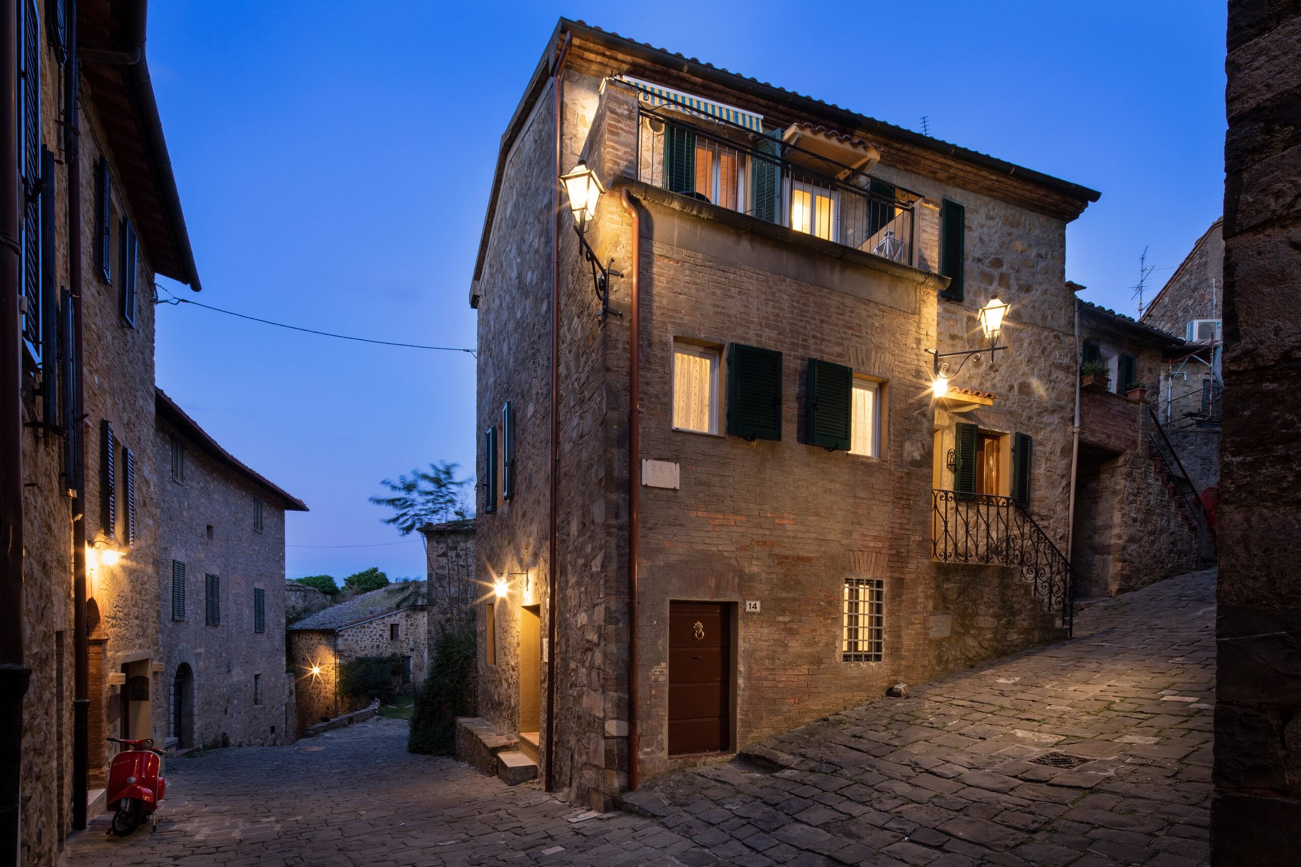 A lit stone façade in the village of Sant'Angelo in Colle at blue hour