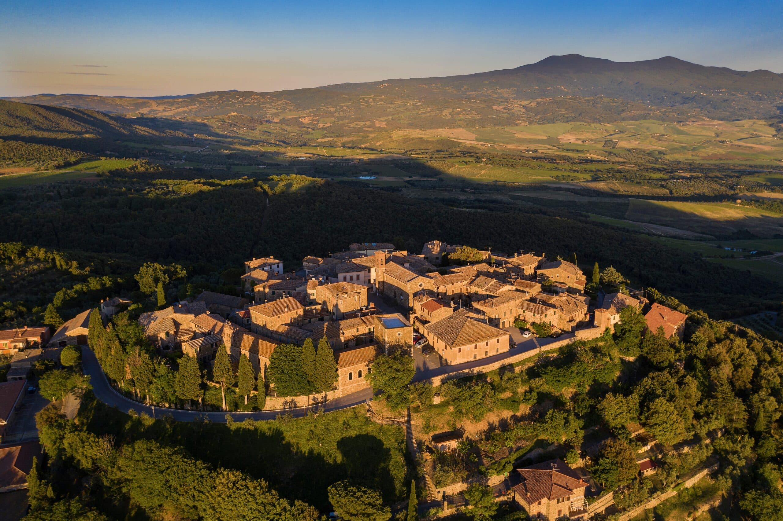 Sant'Angelo in Colle dall'alto nella luce dorata, con il Monte Amiata sullo sfondo