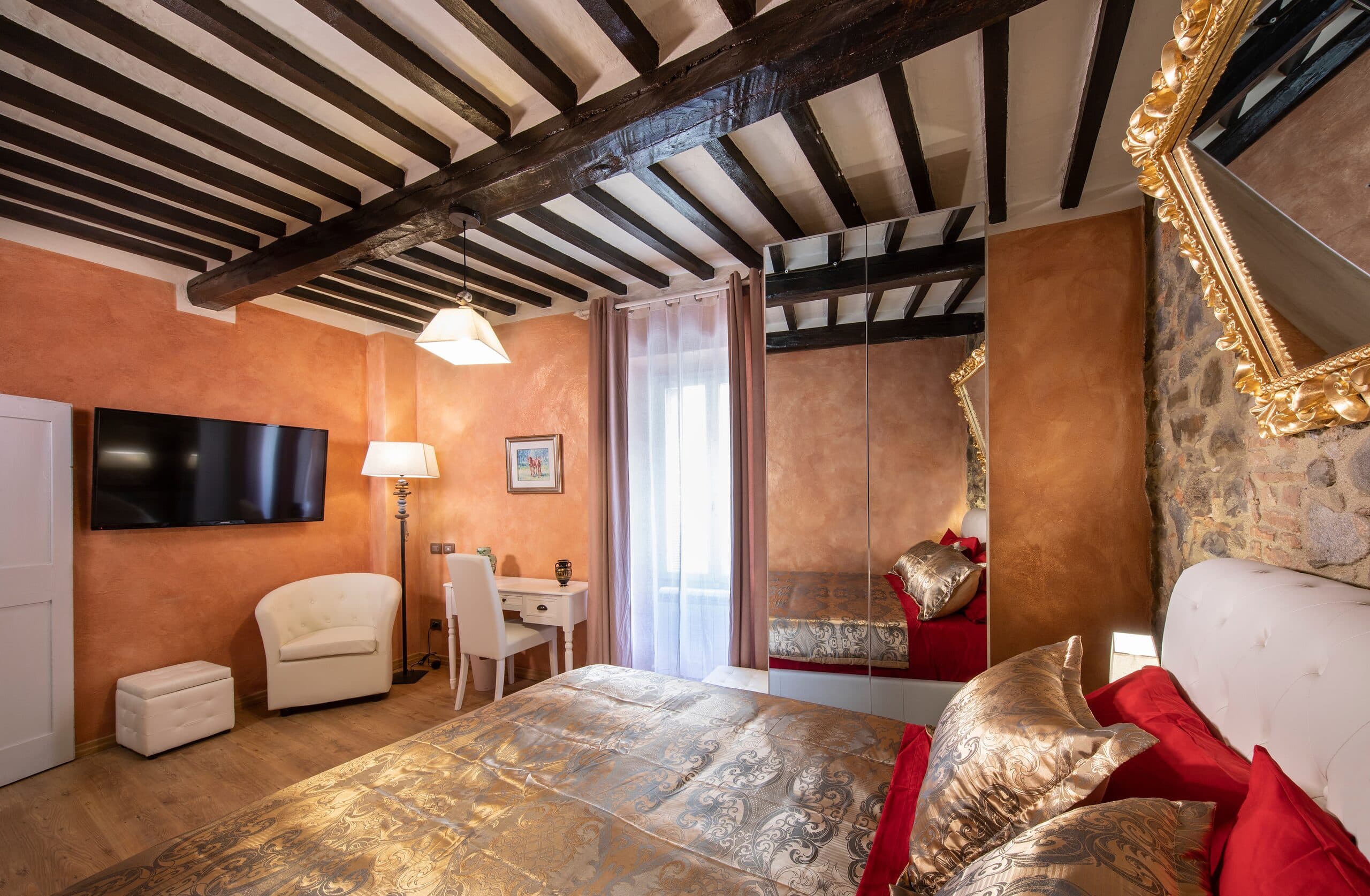 The Cleopatra bedroom with its TV, in warm terracotta tones