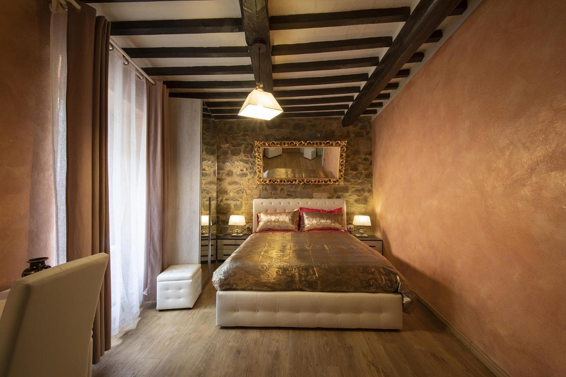 The Matrimoniale di Cleopatra beneath its chestnut-beam ceiling