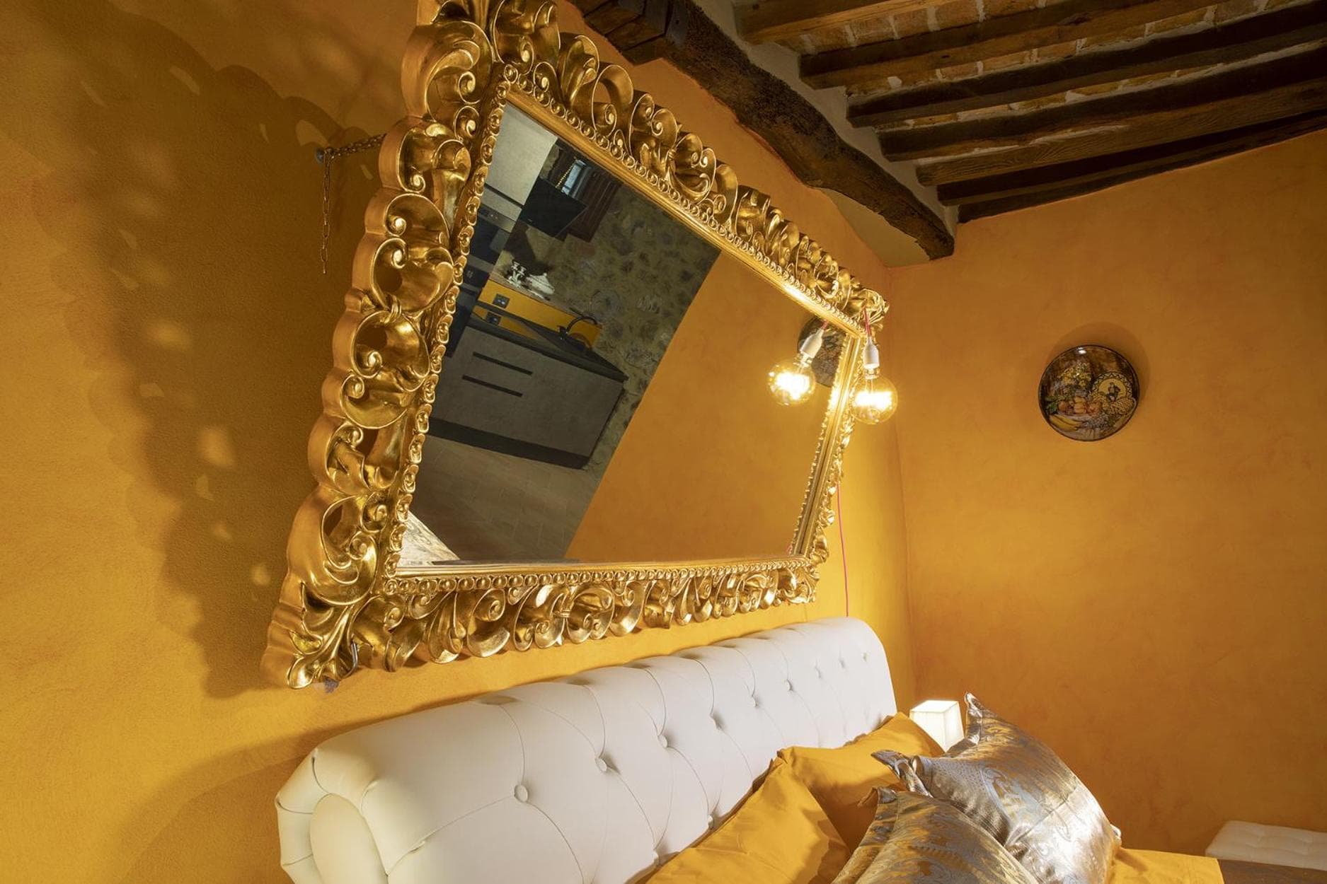 The double play of gilded mirrors above the Suite dell'Oro's bed